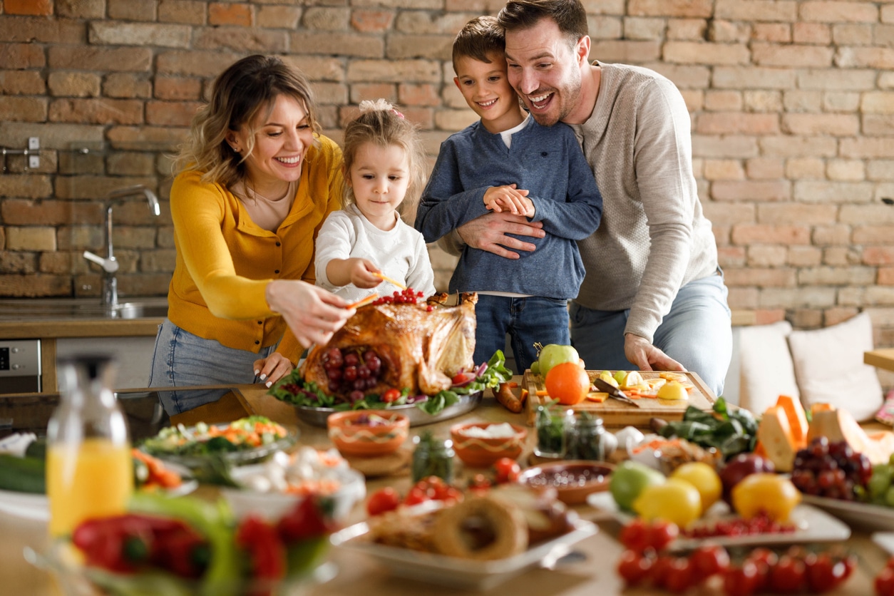 Family putting the finishing touches on their thanksgiving turkey.