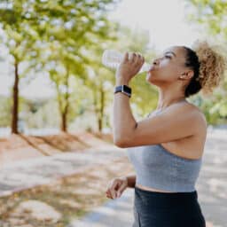 Fitness runner woman drinking water