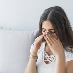 Woman holding her clogged sinuses.